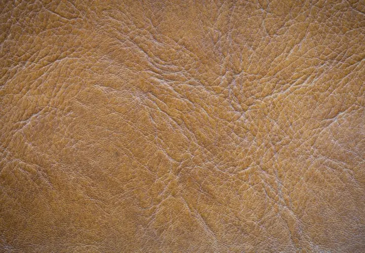 Textura de piel de serraje marrón con arrugas y pliegues. Este material es resistente y la piel de serraje se puede mojar sin problemas.