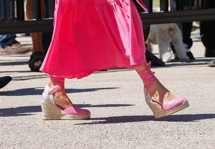 Pie de la Reina Letizia luciendo unas alpargatas de cuña rosas con cintas atadas al tobillo, combinadas con un vestido fucsia.
