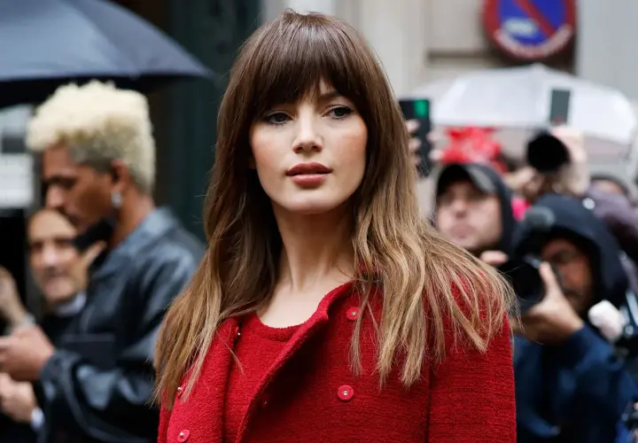 Mujer con flequillo y cabello largo ondulado, un estilo que podría marcar tendencia en cortes de pelo 2026 mujer.