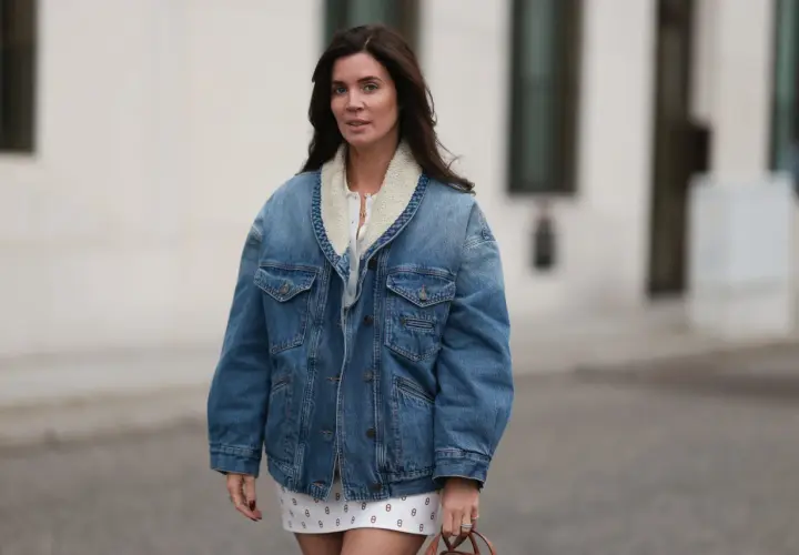 Mujer con chaqueta vaquera forrada y falda estampada. Un look casual y chic, ideal para saber con que combinar chaqueta vaquera mujer.