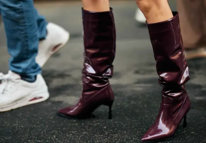 Se llevan las botas altas de charol burdeos, combinadas con vaqueros y zapatillas blancas.