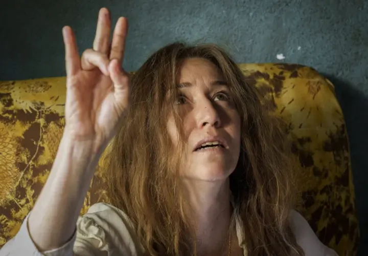 Irene Balmes, con el pelo revuelto, levanta la mano en un gesto místico.