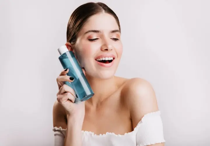 Mujer sonriente con botella de colonia blue Mercadona.