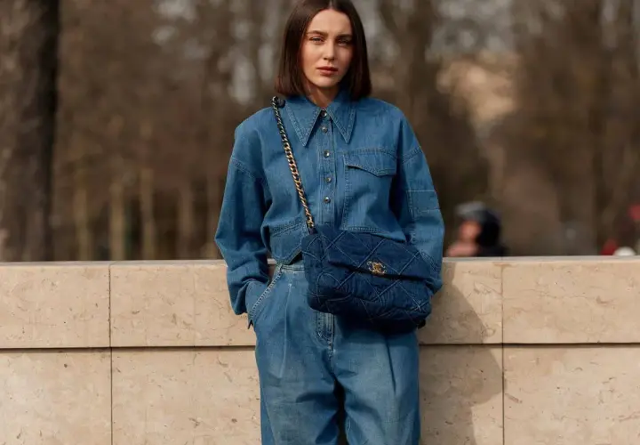 Mujer con un look total denim, combinando mono vaquero con bolso acolchado.