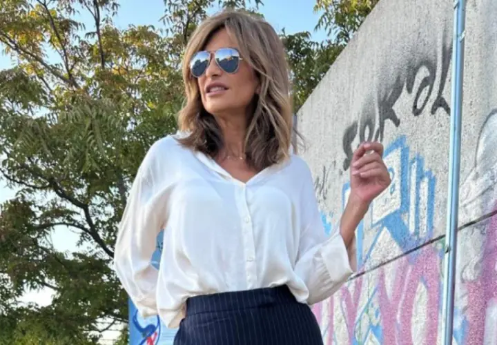 Mujer con estilo combina pantalón raya diplomática con camisa blanca. Look elegante y moderno.