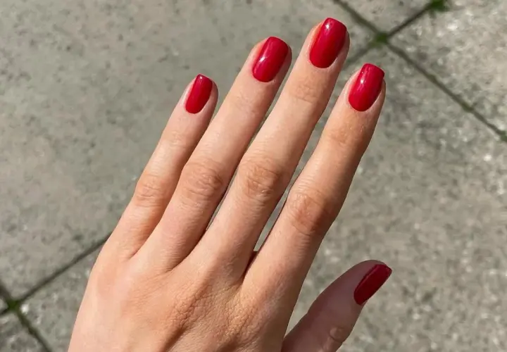 Manos con uñas rojas decoradas elegantes, un toque de glamour para cualquier ocasión.