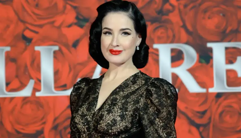 Dita Von Teese, con su estilo retro y labios rojos, brilla en un evento de gala. Un **invierno brillante** de glamour y elegancia.
