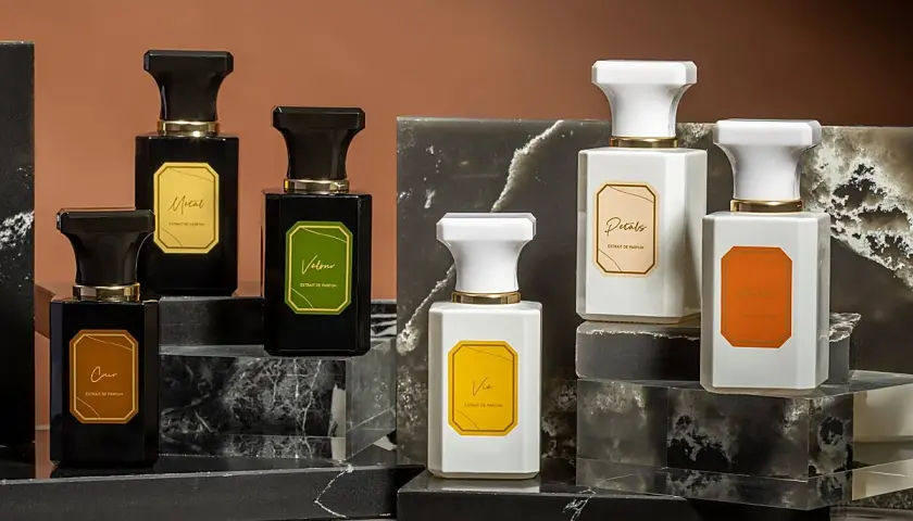 Elegantes frascos de perfume, algunos negros y otros blancos, con etiquetas doradas. Podrían ser la mejor colonia Mercadona hombre.