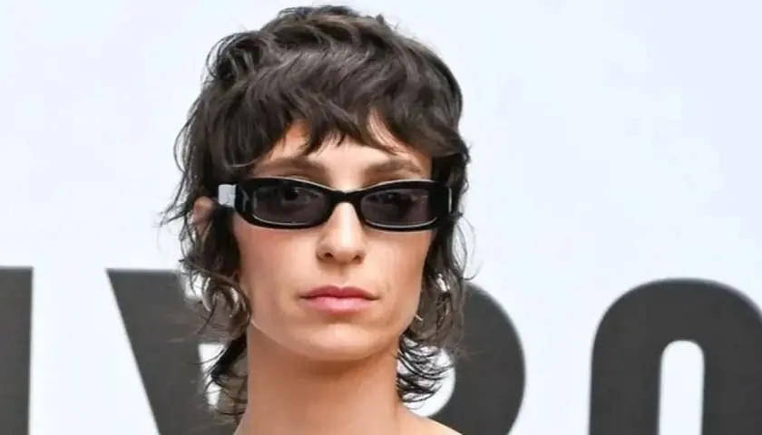 Mujer con gafas oscuras y un moderno mullet corto, luciendo un estilo audaz.