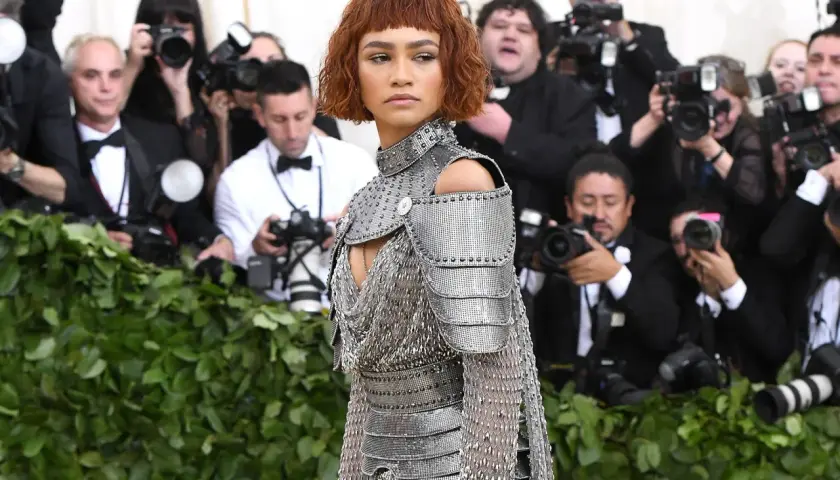 Zendaya, deslumbrante con armadura plateada, posa ante la prensa en un evento.