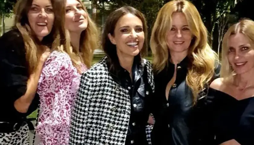 Cinco amigas disfrutan de una cena, luciendo elegantes outfits.