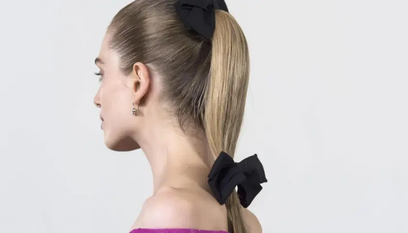 Coleta para invitada boda, con dos lazos negros, uno en la coronilla y otro en la cola de caballo. Elegante y chic.