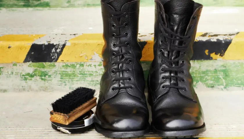 Botas militares negras, cepillo y betún. Aprende como limpiar botas militares para que luzcan impecables.