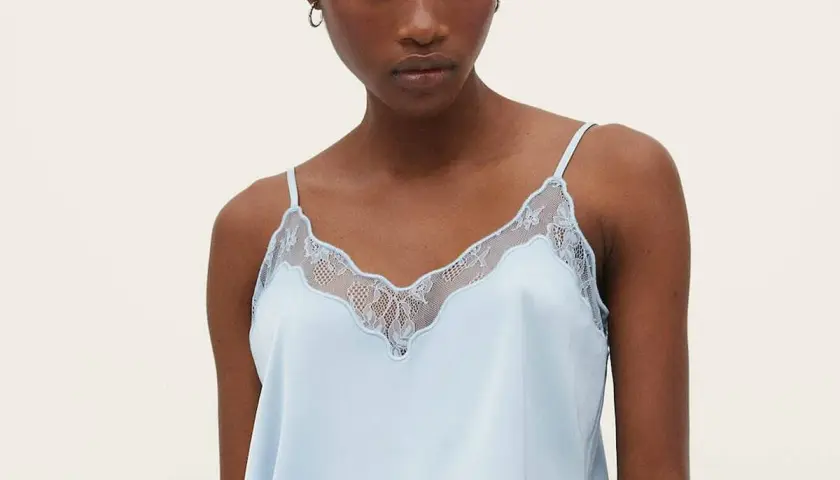 Un top lencero azul claro con detalles de encaje, ideal para lucir diferentes tipos de tops con estilo.