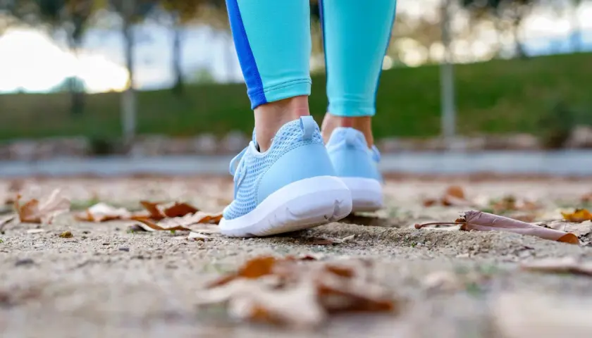 Zapatillas woman azules, listas para caminar entre hojas secas en un día fresco.