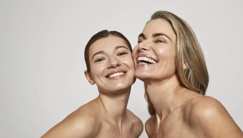 Dos mujeres sonríen, sus rostros radiantes y piel luminosa, un reflejo de la confianza que brinda Oslo Skin Lab.