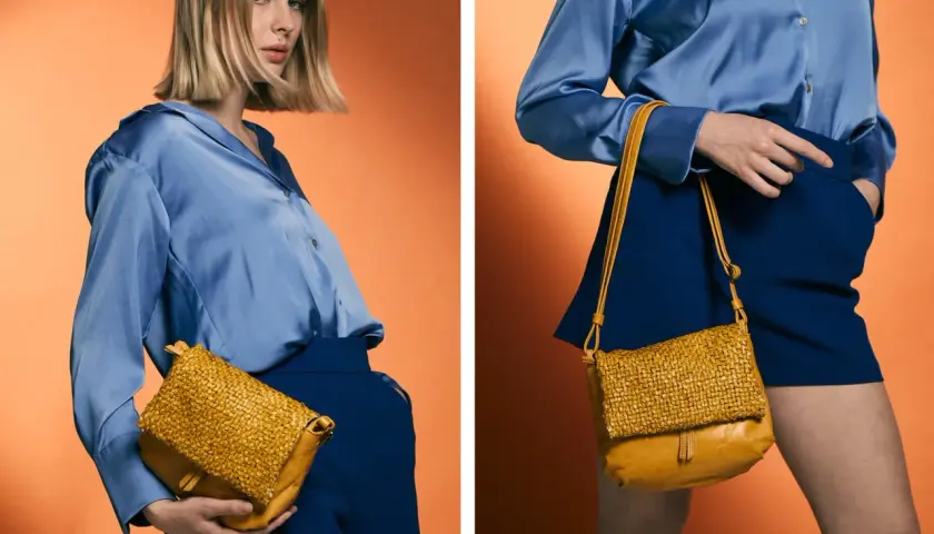 Mujer con blusa azul y falda azul, mostrando cómo combinar bolso marrón tejido.
