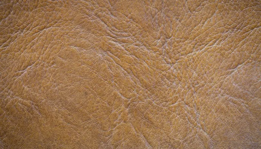 Textura de piel de serraje marrón con arrugas y pliegues. Este material es resistente y la piel de serraje se puede mojar sin problemas.