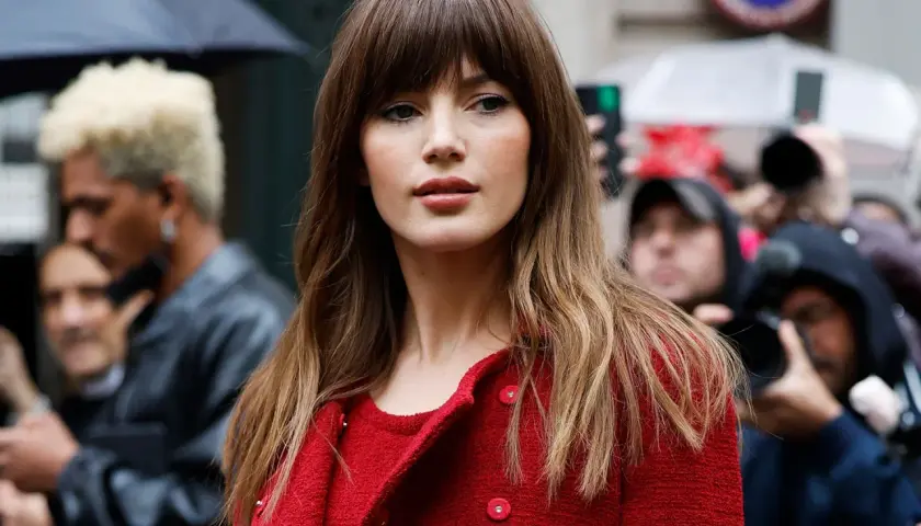 Mujer con flequillo y cabello largo ondulado, un estilo que podría marcar tendencia en cortes de pelo 2026 mujer.