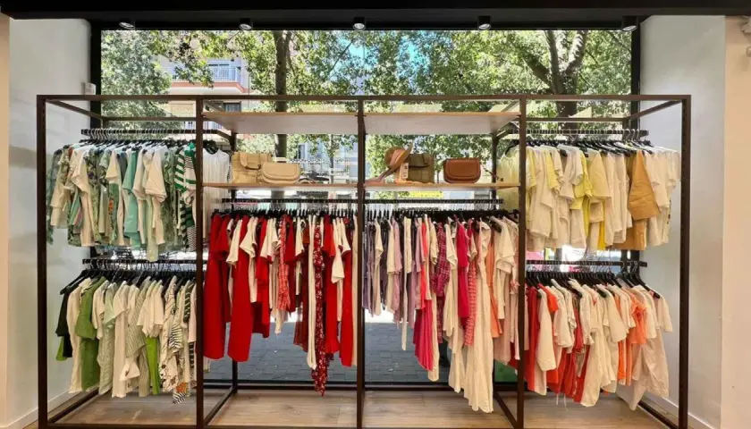 Exhibición de ropa de verano en tiendas grupo Inditex. Vestidos, blusas y accesorios en tonos pastel y vibrantes.