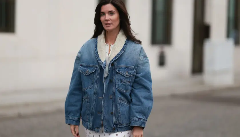 Mujer con chaqueta vaquera forrada y falda estampada. Un look casual y chic, ideal para saber con que combinar chaqueta vaquera mujer.