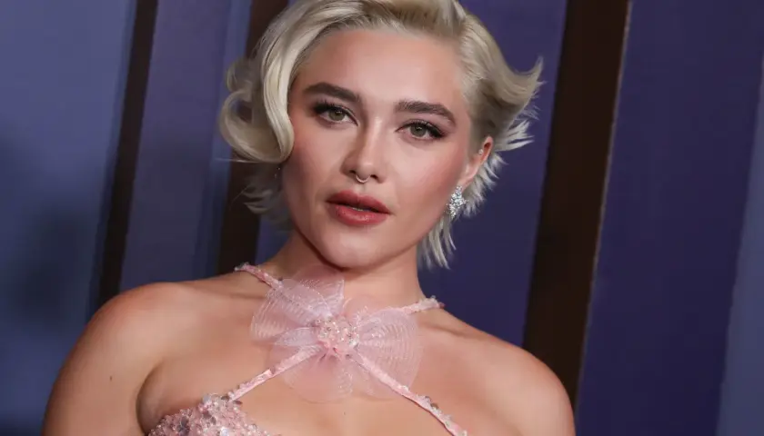 Mujer joven con corte de pelo rubio platino, estilo pixie con ondas. Un look moderno que inspira cortes de pelo corto mujer de 60 años.