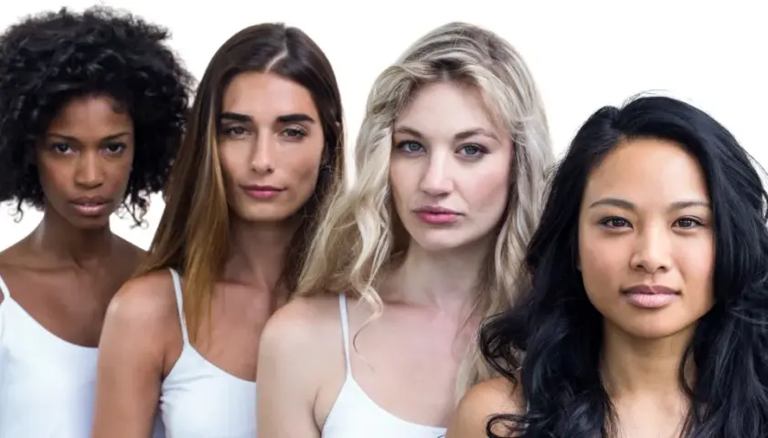 Cuatro mujeres de diferentes etnias, con labios en un suave color coral, posan juntas.
