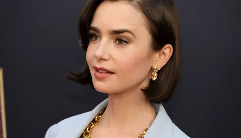 Mujer con un corte de pelo estilo **italian bob**, pendientes dorados y un collar llamativo.