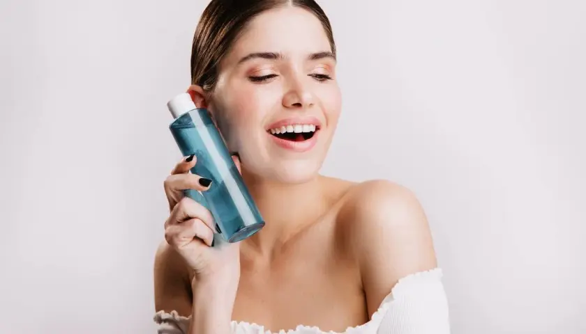 Mujer sonriente con botella de colonia blue Mercadona.
