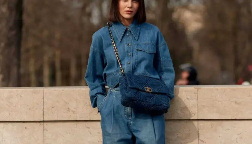 Mujer con un look total denim, combinando mono vaquero con bolso acolchado.