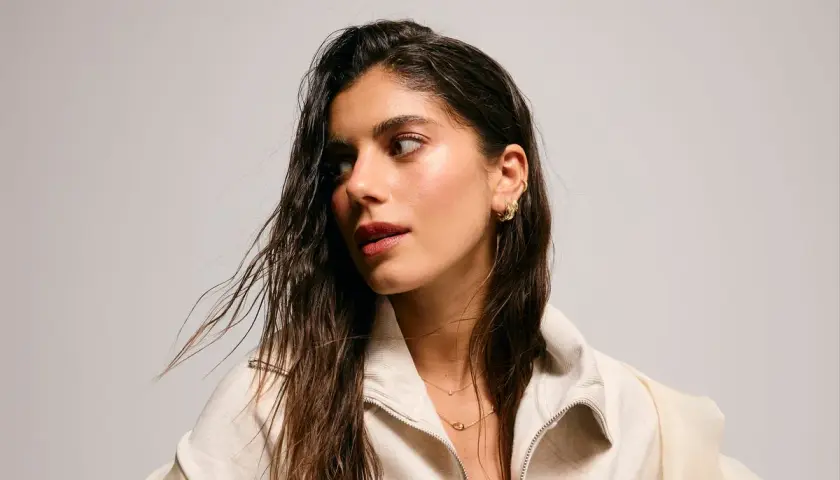 Sara Baceiredo, con su cabello largo y húmedo, luce un collar delicado y pendientes dorados.