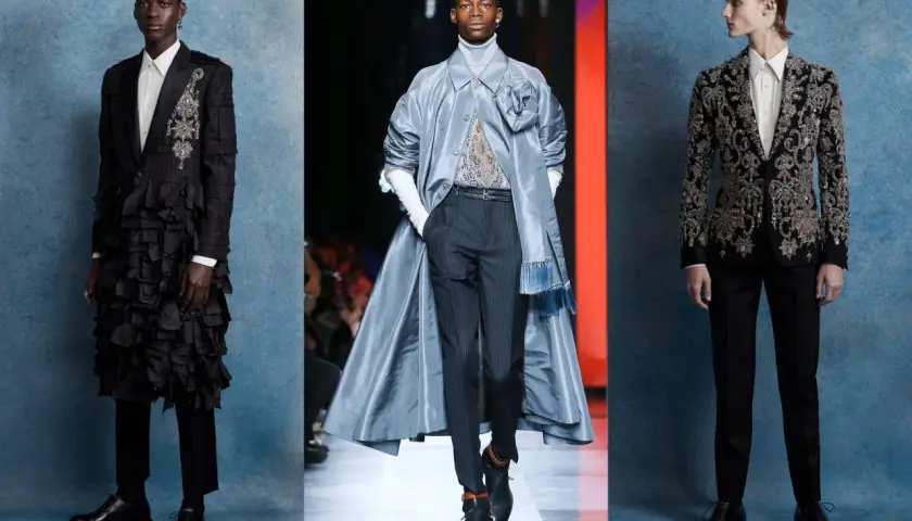 Tres modelos masculinos lucen trajes de alta costura con un aire de la época victoriana: uno con volantes negros, otro con un abrigo azul y un tercero con un traje bordado.