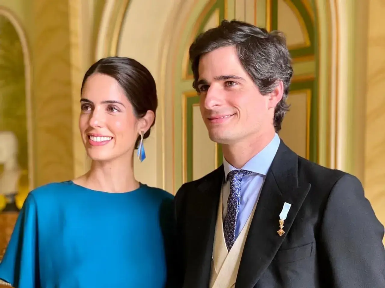 Los duques de Huéscar, sonrientes y elegantes, posan para la foto en un salón de época.