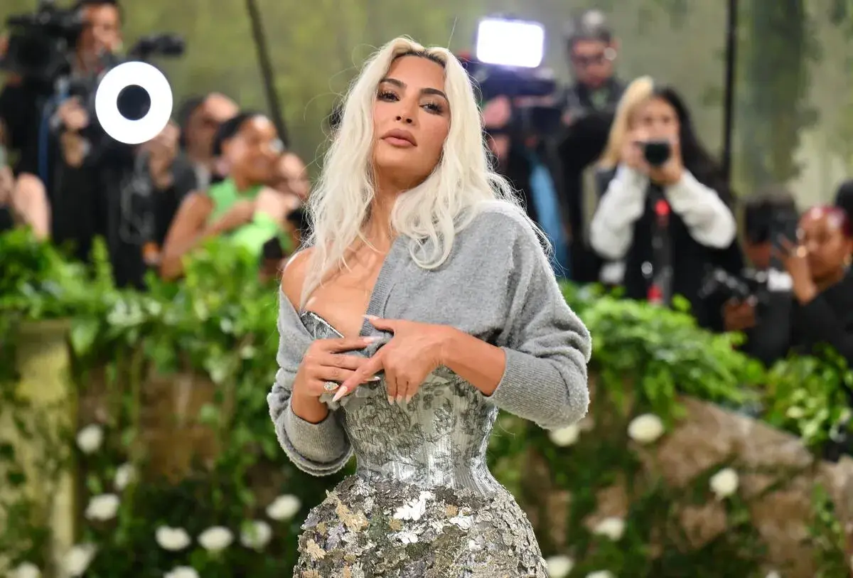 Kim Kardashian deslumbró en la Met Gala con un corsé plateado y un suéter gris.