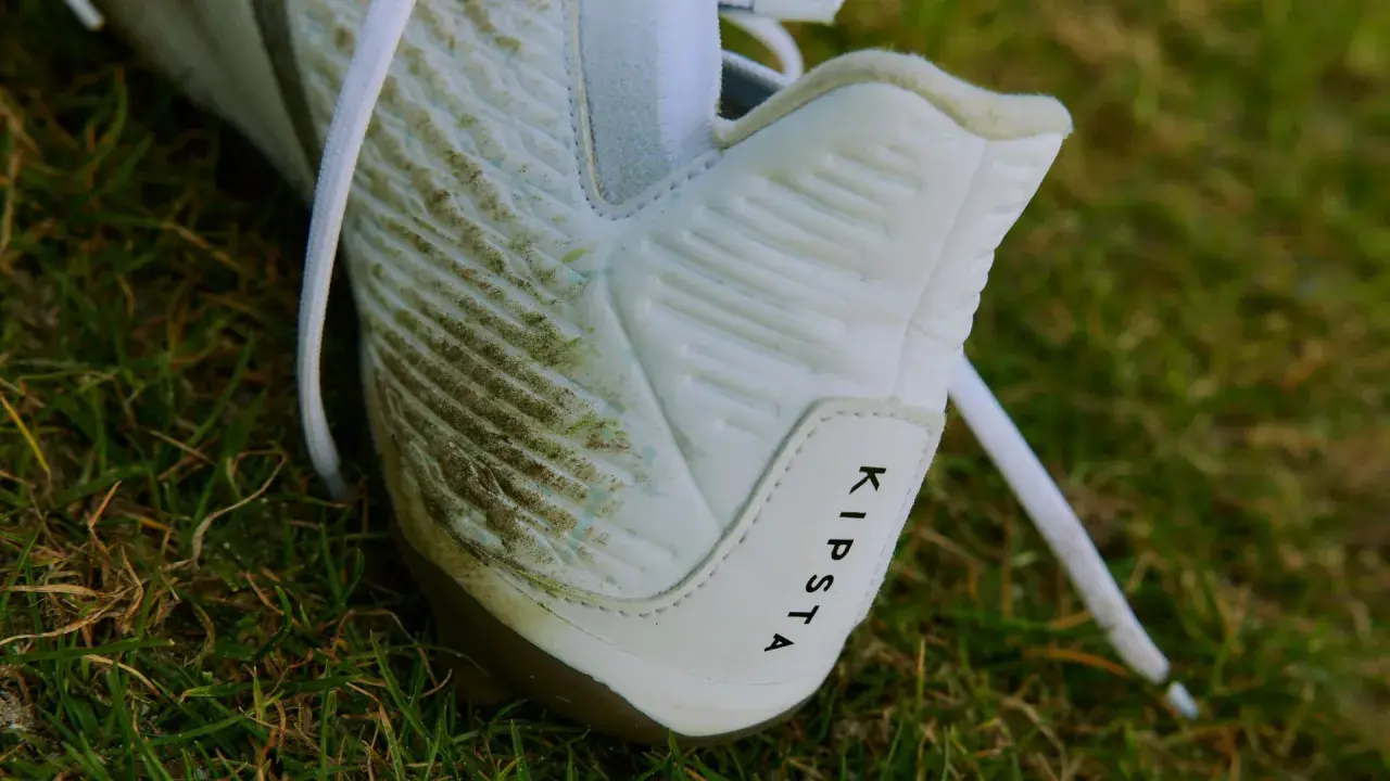 Botas de fútbol Kipsta sucias en el césped. Aprende como limpiar unas botas para dejarlas como nuevas.
