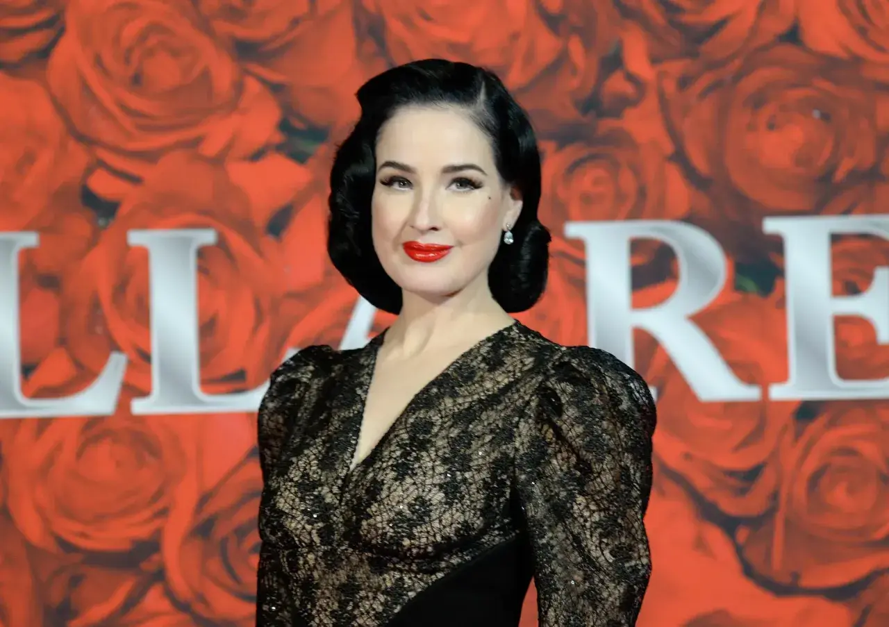 Dita Von Teese, con su estilo retro y labios rojos, brilla en un evento de gala. Un **invierno brillante** de glamour y elegancia.