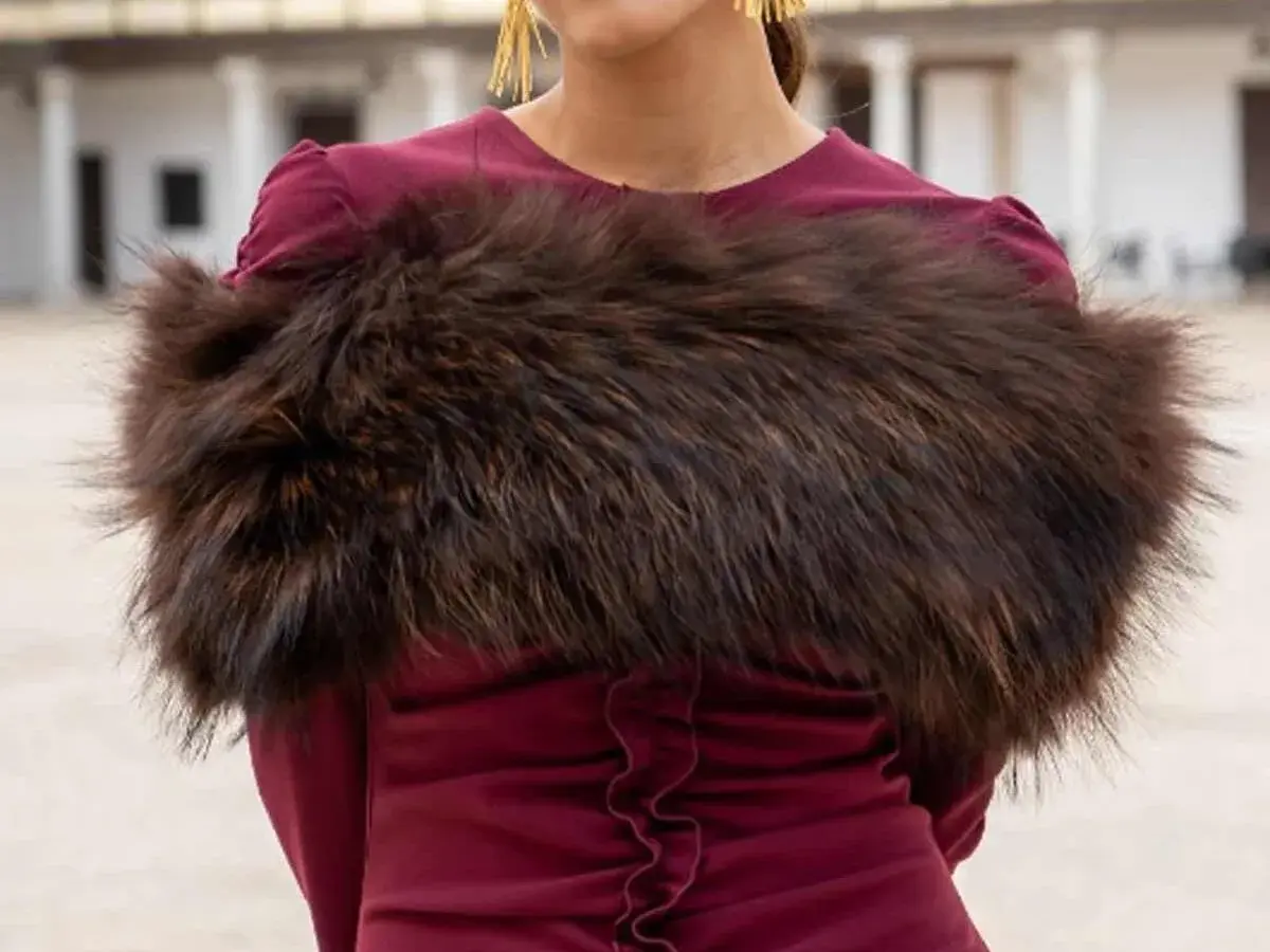 Elegante estola de pelo marrón sobre vestido burdeos, ideal para saber como llevar una estola en una boda y lucir sofisticada.