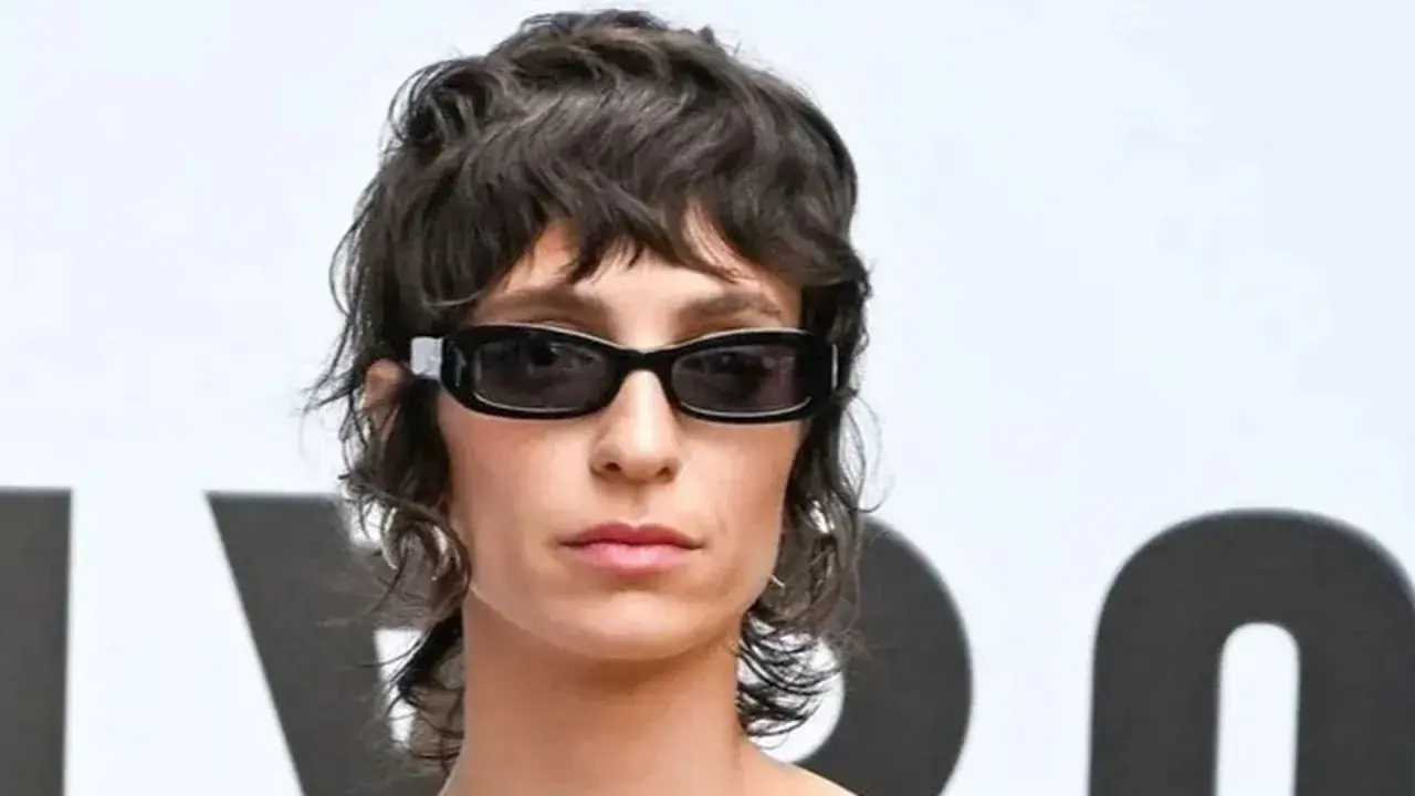 Mujer con gafas oscuras y un moderno mullet corto, luciendo un estilo audaz.