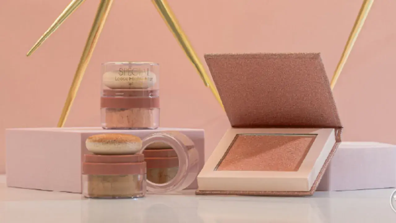 Dos envases de iluminador sueltos y un iluminador en polvo compacto, todos con tonos dorados y rosados, listos para dar luz a tu rostro.