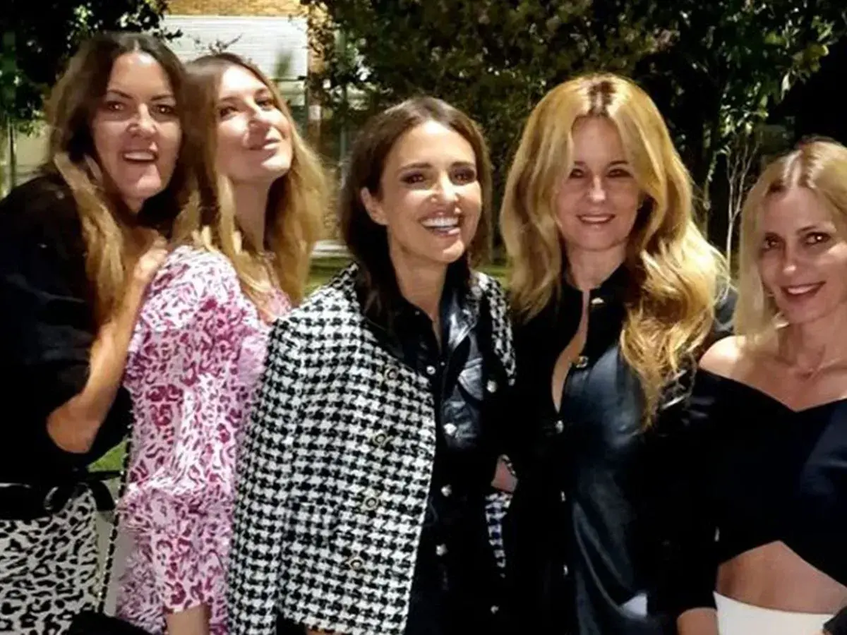 Cinco amigas disfrutan de una cena, luciendo elegantes outfits.