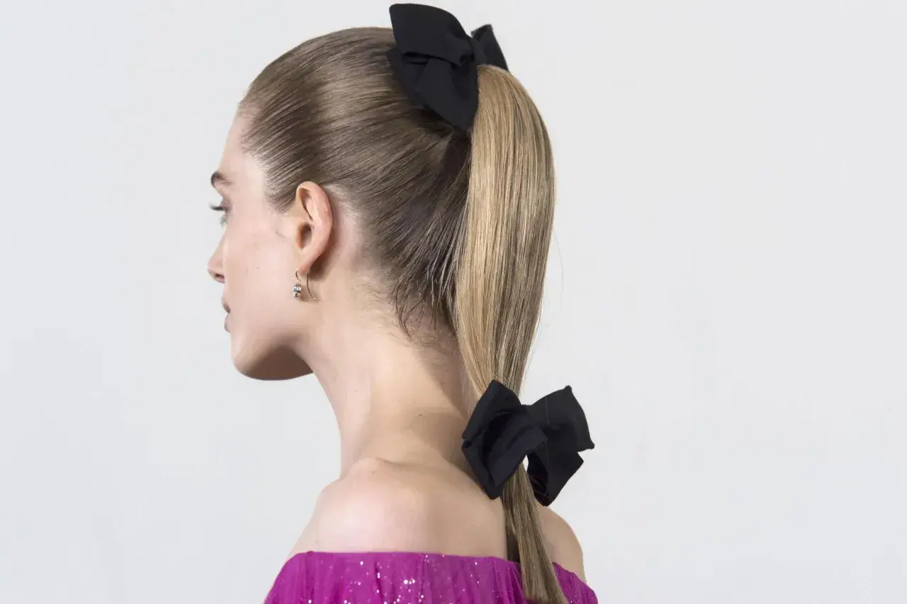 Coleta para invitada boda, con dos lazos negros, uno en la coronilla y otro en la cola de caballo. Elegante y chic.