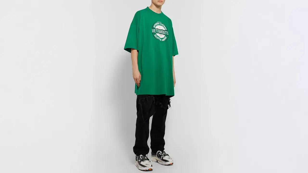 Camiseta verde de **oversize significado** con logo de Vetements, combinada con vaqueros negros rotos y zapatillas deportivas.