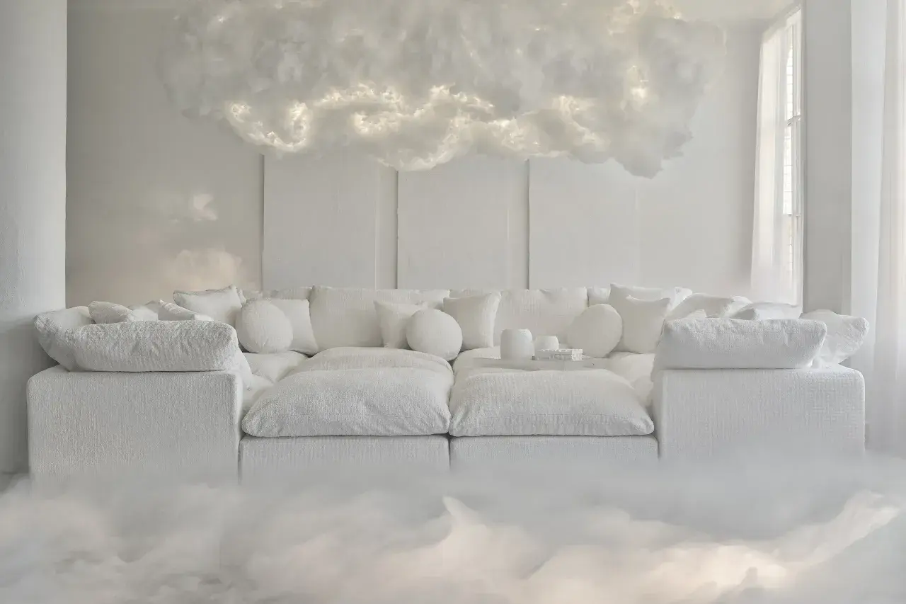 Sofá blanco etéreo con cojines mullidos, suspendido entre nubes luminosas. Un sueño de **pantone 2026** hecho realidad.