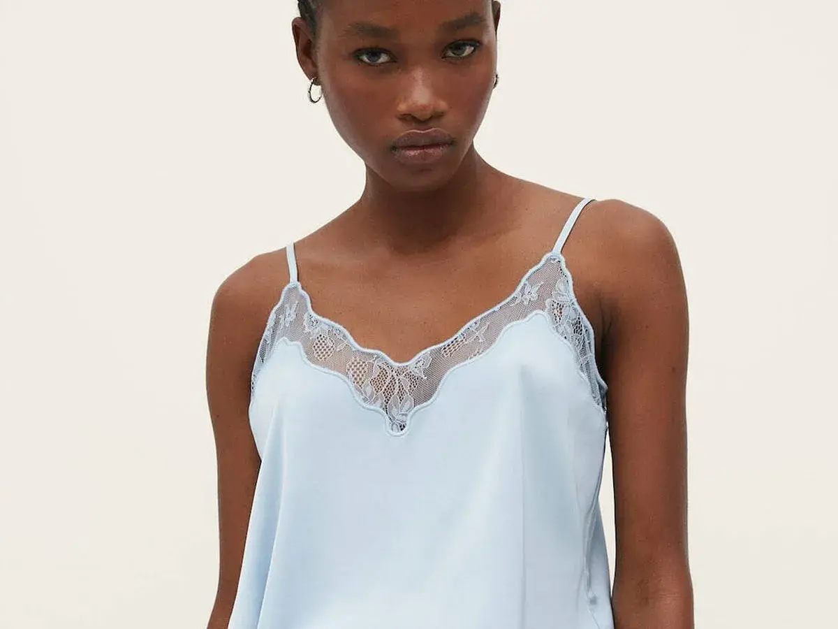 Un top lencero azul claro con detalles de encaje, ideal para lucir diferentes tipos de tops con estilo.