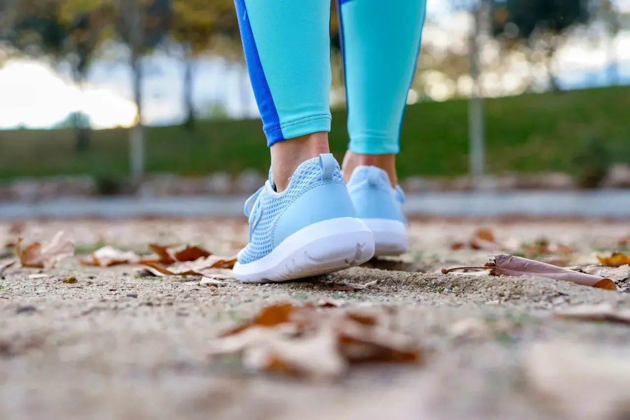 Zapatillas woman azules, listas para caminar entre hojas secas en un día fresco.