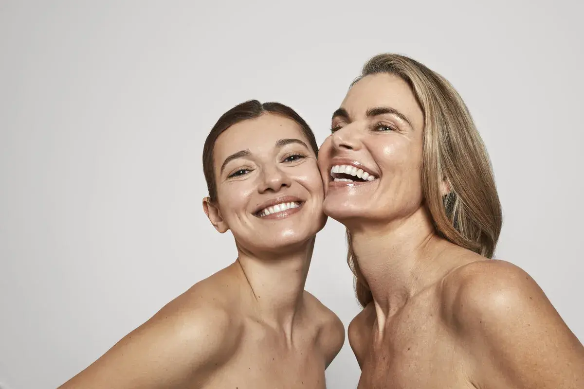 Dos mujeres sonríen, sus rostros radiantes y piel luminosa, un reflejo de la confianza que brinda Oslo Skin Lab.
