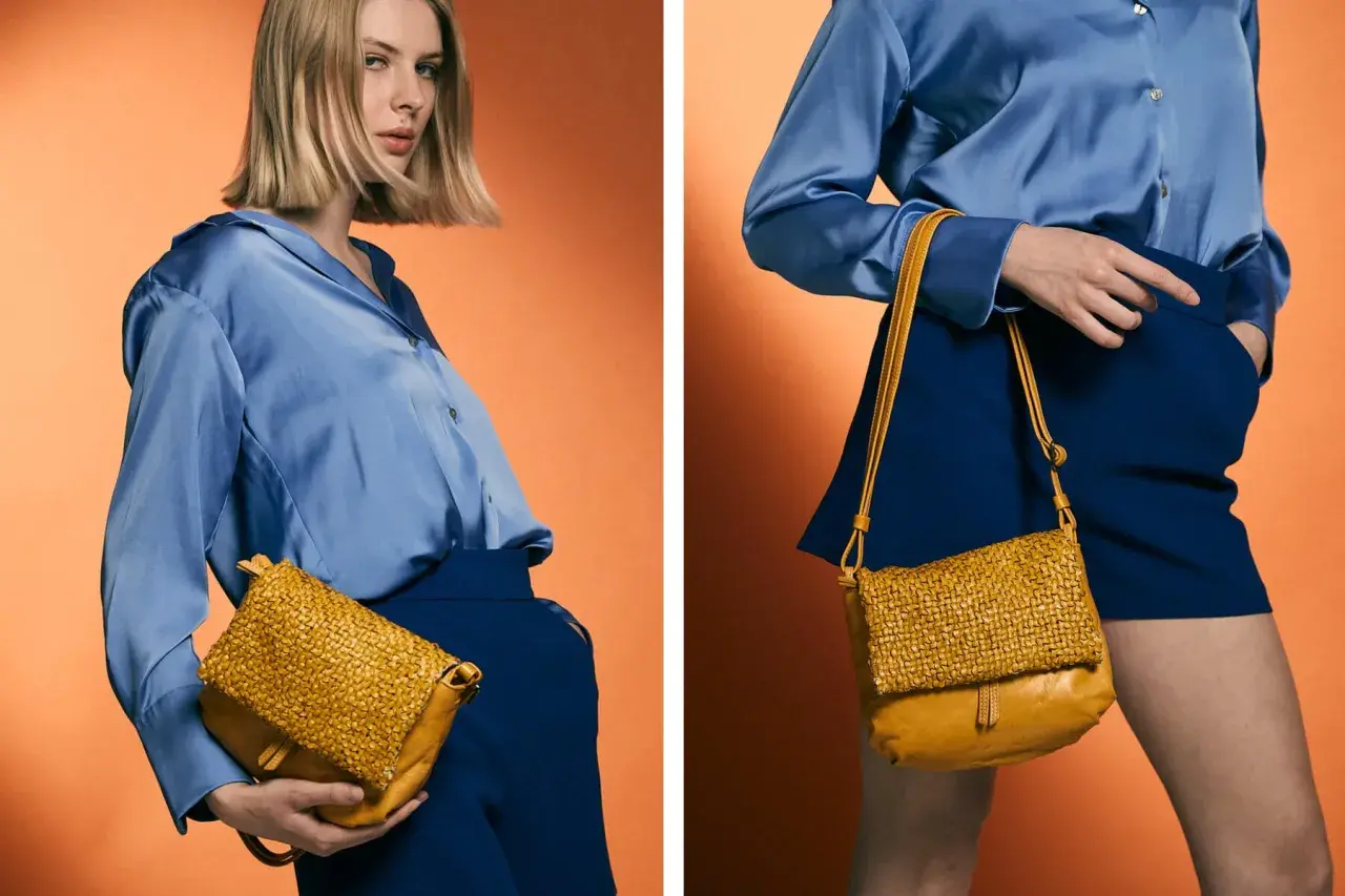 Mujer con blusa azul y falda azul, mostrando cómo combinar bolso marrón tejido.