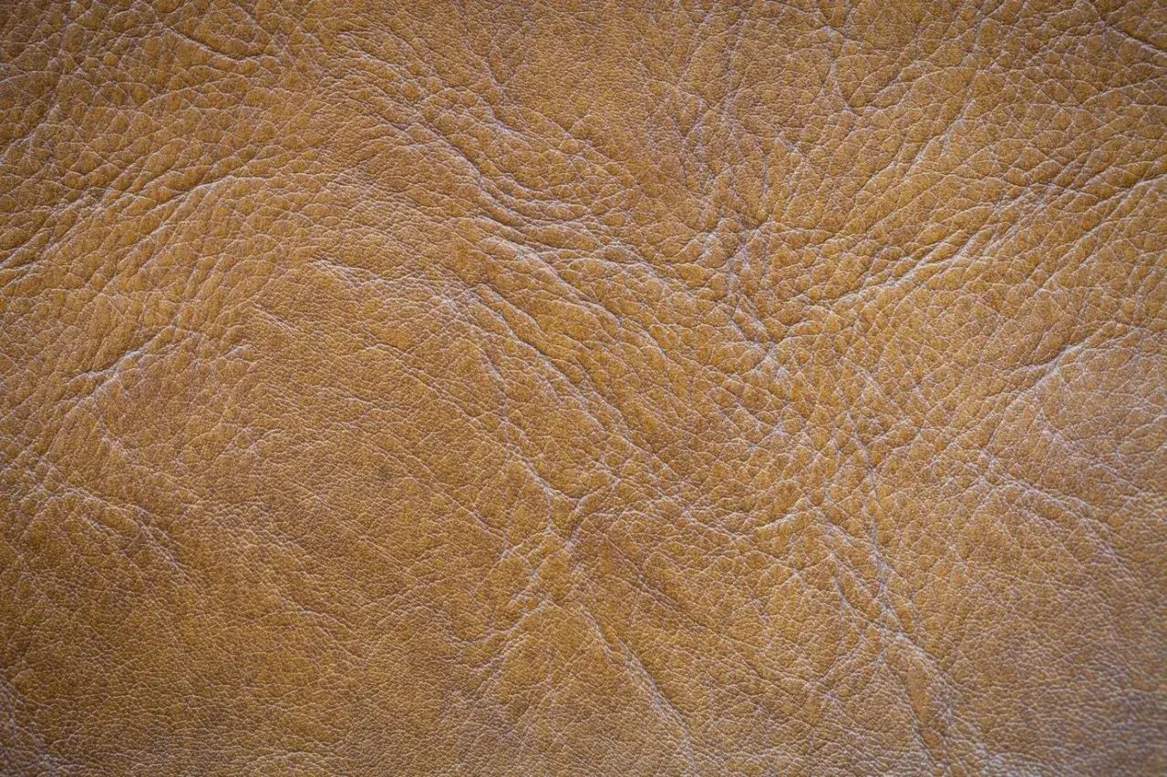 Textura de piel de serraje marrón con arrugas y pliegues. Este material es resistente y la piel de serraje se puede mojar sin problemas.