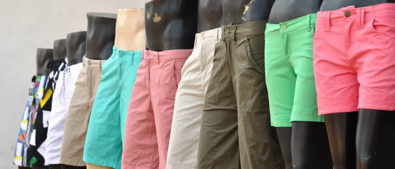Varios maniquíes exhiben un outfit de pantalon corto hombre en colores vibrantes: rosa, verde, beige y con estampados.