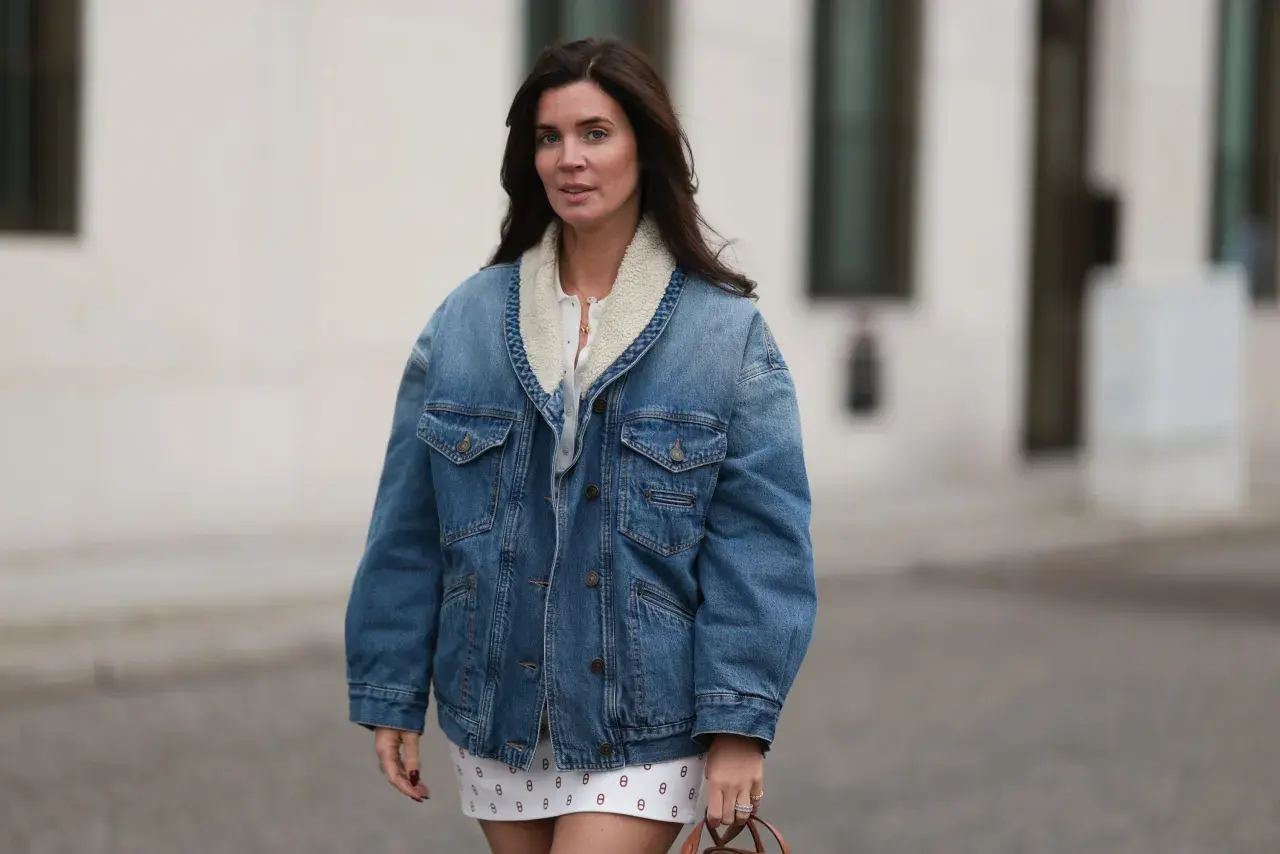 Mujer con chaqueta vaquera forrada y falda estampada. Un look casual y chic, ideal para saber con que combinar chaqueta vaquera mujer.